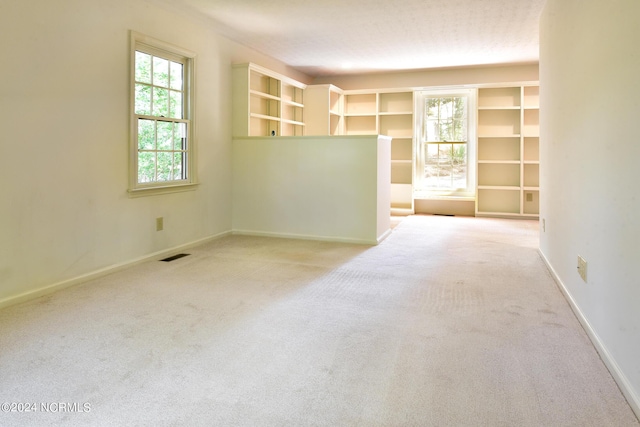 empty room featuring carpet, visible vents, and baseboards