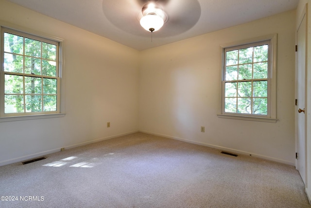 unfurnished room with ceiling fan, baseboards, visible vents, and light colored carpet