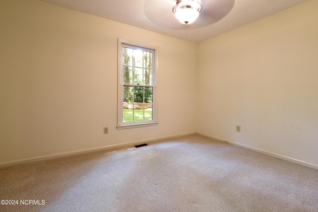 carpeted empty room featuring ceiling fan, visible vents, and baseboards