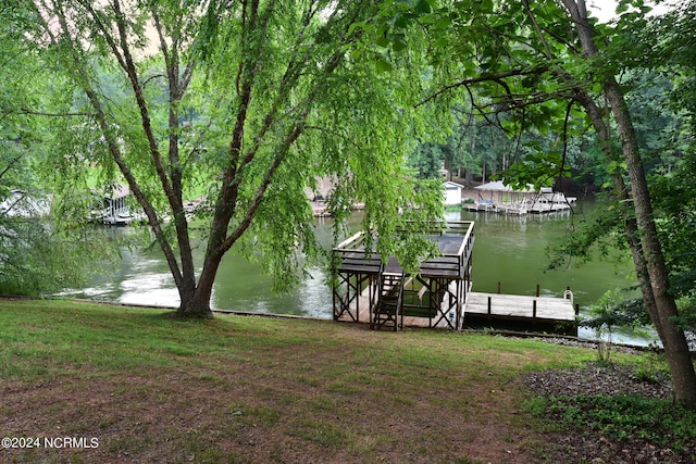 view of dock with a water view and a lawn