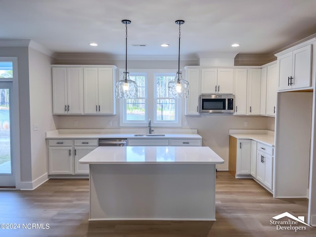 kitchen featuring a kitchen island, white cabinetry, sink, and appliances with stainless steel finishes