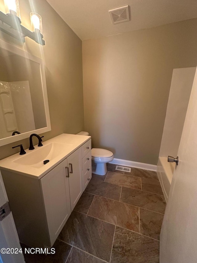 full bath featuring toilet, vanity, visible vents, and baseboards