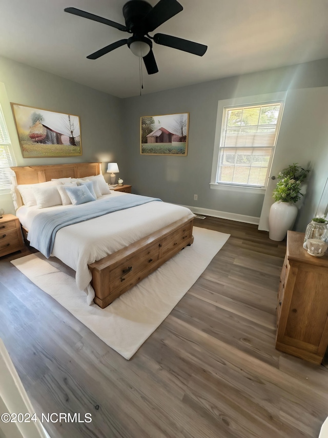 bedroom featuring ceiling fan, baseboards, and wood finished floors