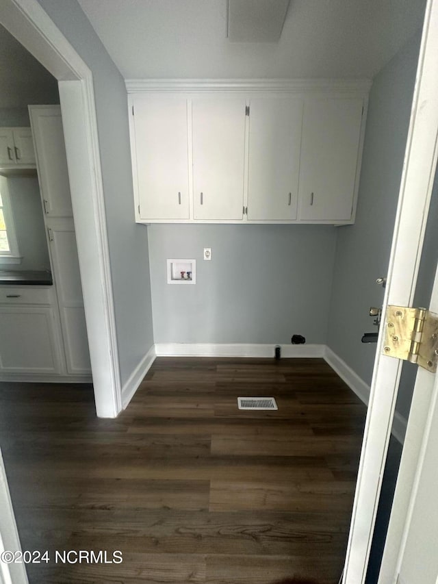 washroom featuring dark wood-style flooring, hookup for a washing machine, visible vents, cabinet space, and baseboards