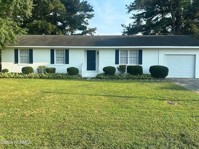 ranch-style house featuring a garage, aphalt driveway, a front lawn, and brick siding