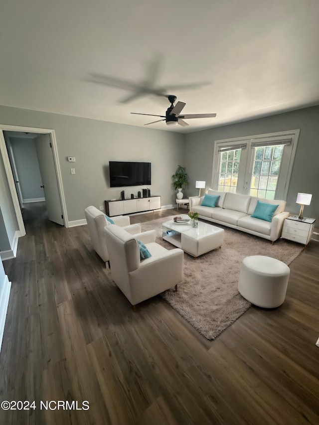 living room with dark hardwood / wood-style flooring and ceiling fan