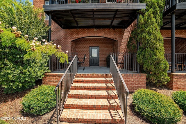 property entrance with covered porch and brick siding