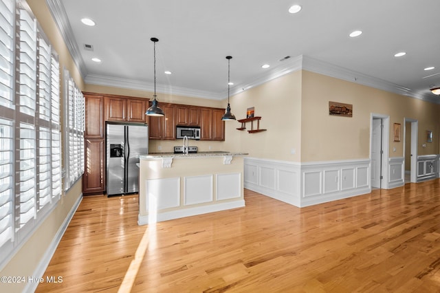 kitchen featuring decorative light fixtures, stainless steel appliances, recessed lighting, a kitchen island with sink, and light wood-type flooring