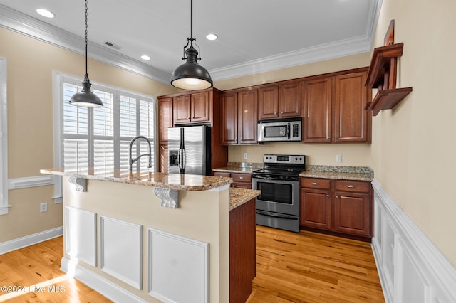 kitchen with light stone countertops, a kitchen breakfast bar, stainless steel appliances, a kitchen island with sink, and light hardwood / wood-style flooring