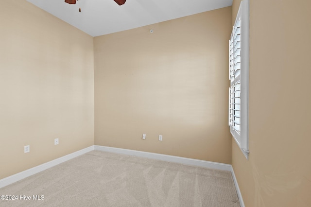 carpeted spare room with ceiling fan