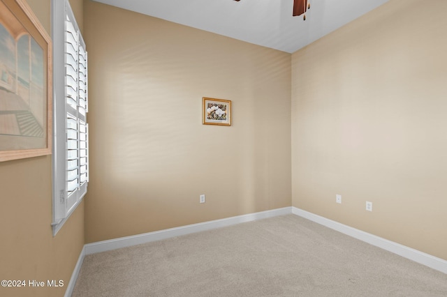 carpeted empty room featuring ceiling fan, a healthy amount of sunlight, and baseboards