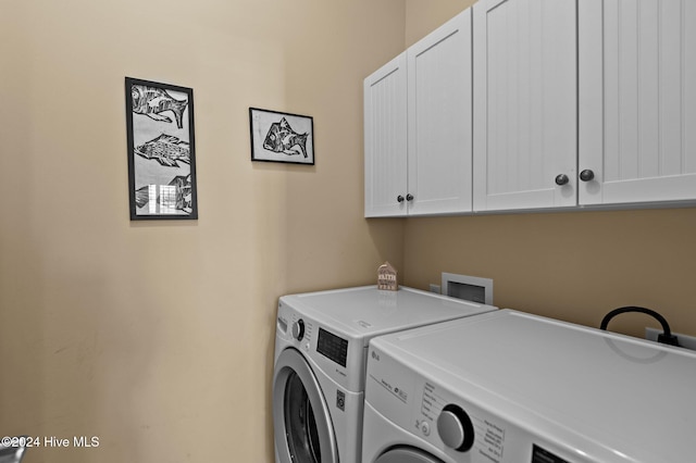 washroom featuring washer and clothes dryer and cabinets