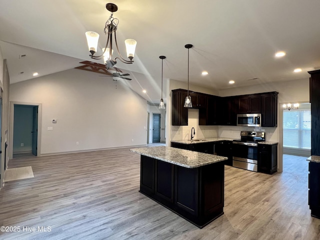 kitchen with pendant lighting, stainless steel appliances, tasteful backsplash, sink, and light wood-type flooring