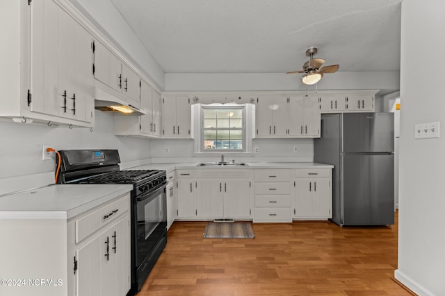 kitchen featuring white cabinets, gas stove, and stainless steel refrigerator