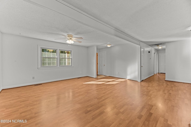 spare room featuring a textured ceiling, light hardwood / wood-style flooring, and ceiling fan