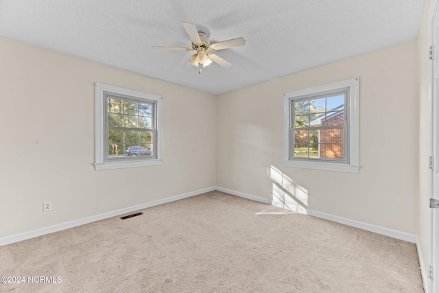 carpeted empty room with a textured ceiling and ceiling fan