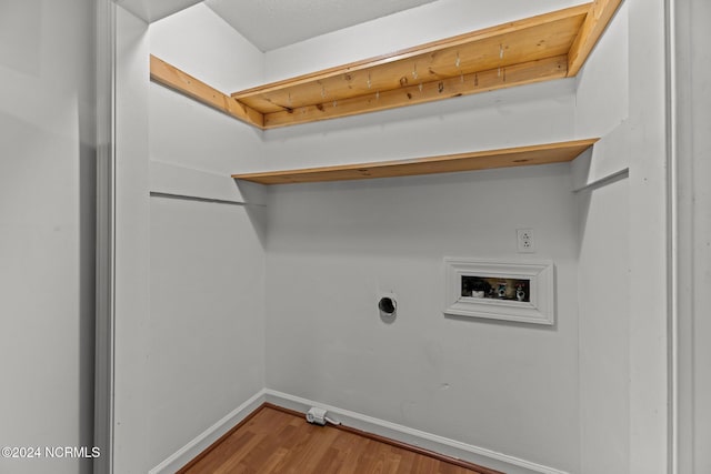 clothes washing area with electric dryer hookup, hookup for a washing machine, and hardwood / wood-style flooring