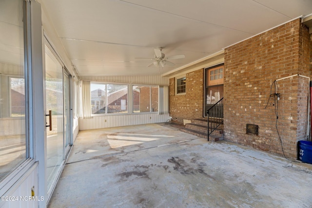 unfurnished sunroom featuring ceiling fan