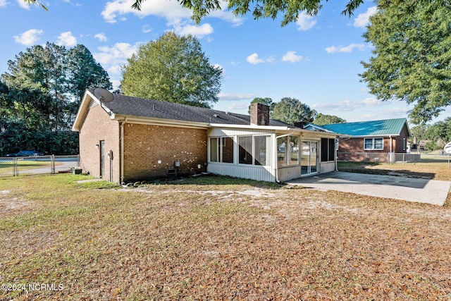 back of house with a patio area, a sunroom, and a yard