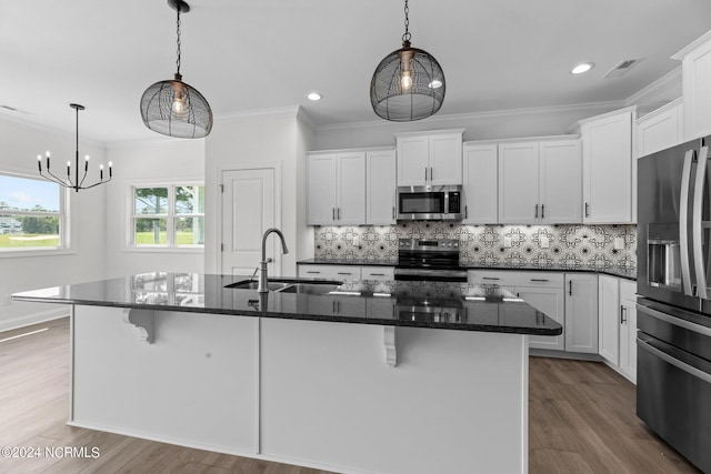 kitchen featuring a breakfast bar, stainless steel appliances, visible vents, backsplash, and a sink