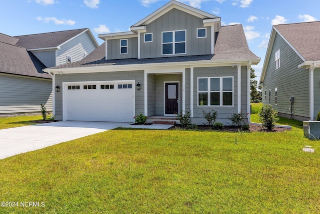 view of front of property with concrete driveway, roof with shingles, board and batten siding, and a front yard