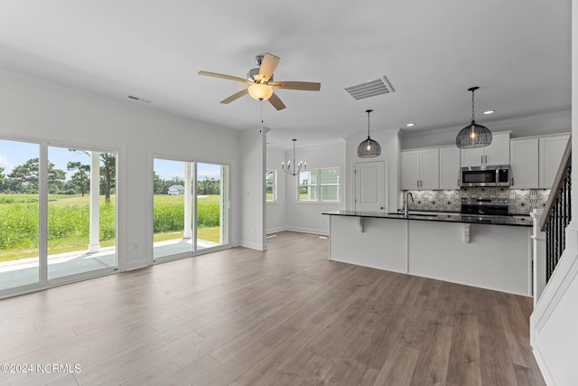 kitchen featuring a breakfast bar area, stainless steel appliances, visible vents, open floor plan, and decorative backsplash