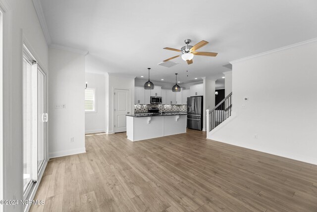 kitchen featuring stainless steel appliances, dark countertops, tasteful backsplash, visible vents, and open floor plan