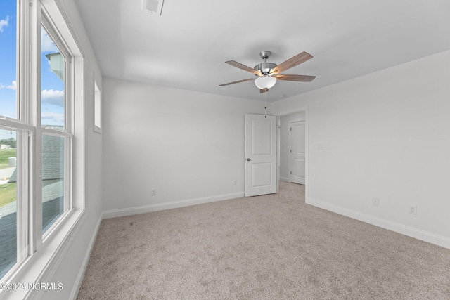 empty room with ceiling fan, carpet, visible vents, and baseboards