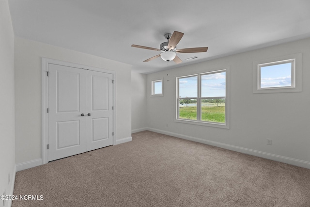 unfurnished bedroom featuring carpet floors, baseboards, visible vents, and a closet