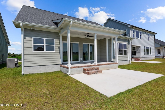 rear view of house with roof with shingles, central air condition unit, a lawn, a ceiling fan, and a patio area