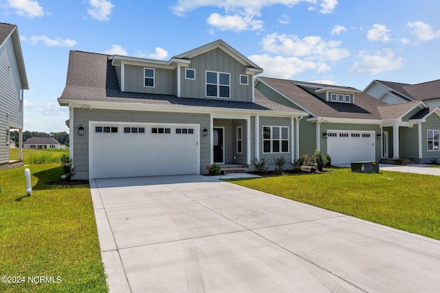 view of front of property with driveway, an attached garage, board and batten siding, and a front yard