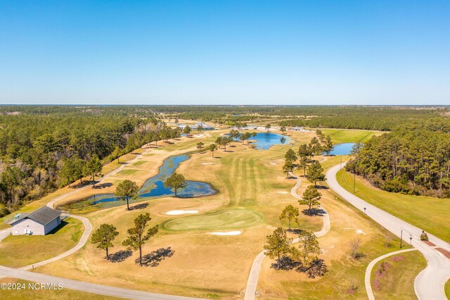 drone / aerial view featuring a water view, a view of trees, and golf course view