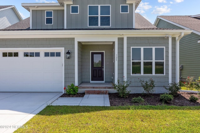 view of front of house with roof with shingles, board and batten siding, a front yard, and driveway