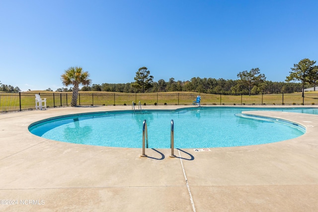 community pool with fence and a patio