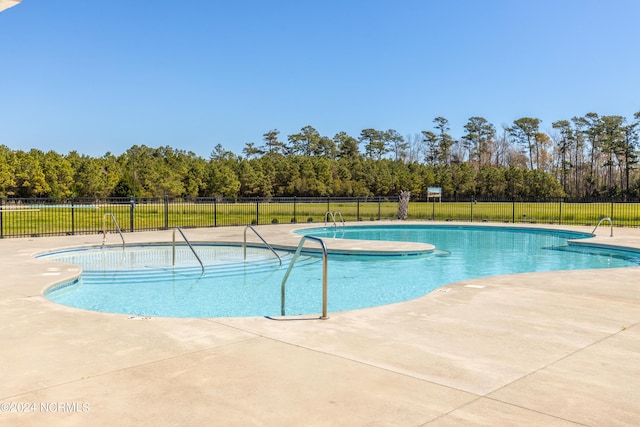 community pool with fence and a patio