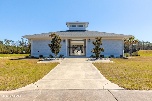 view of front of house featuring driveway, a front lawn, fence, and a gate