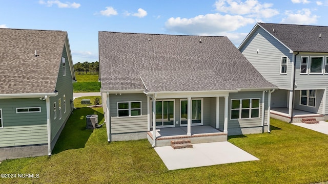 rear view of property with a shingled roof, a patio area, a yard, and central air condition unit