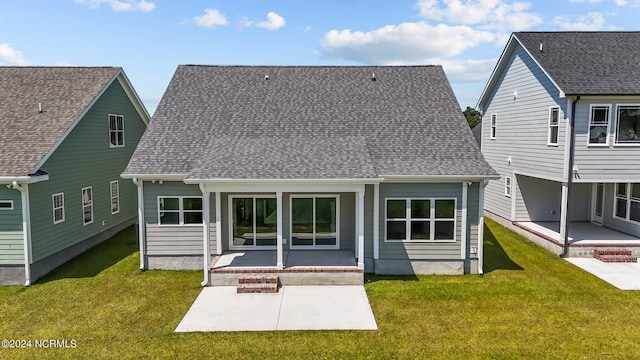 rear view of house with a yard, roof with shingles, and a patio