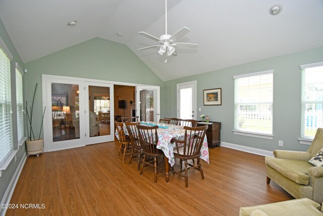 dining room with ceiling fan, french doors, vaulted ceiling, and hardwood / wood-style flooring