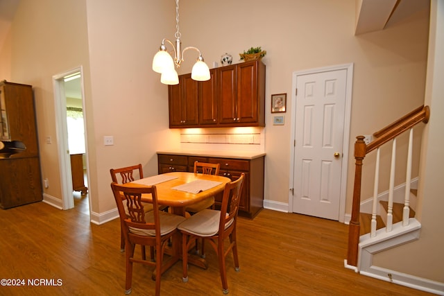 dining area with wood-type flooring and an inviting chandelier