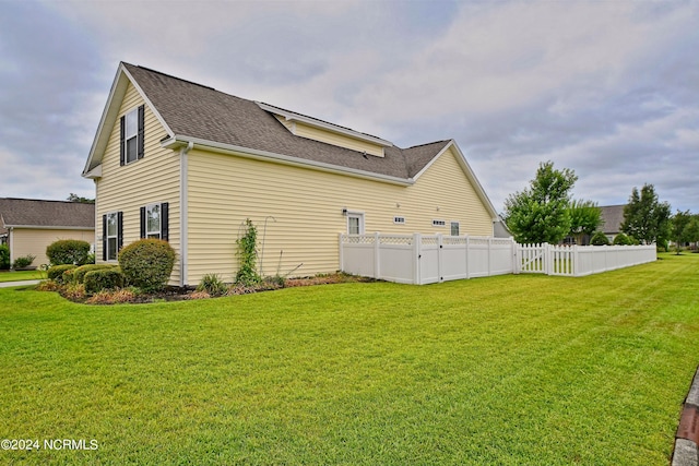 view of side of home with a yard