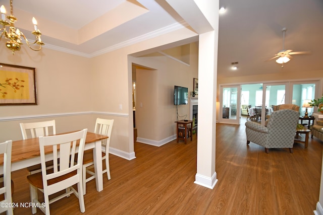 dining space with hardwood / wood-style flooring, ceiling fan, and a tray ceiling