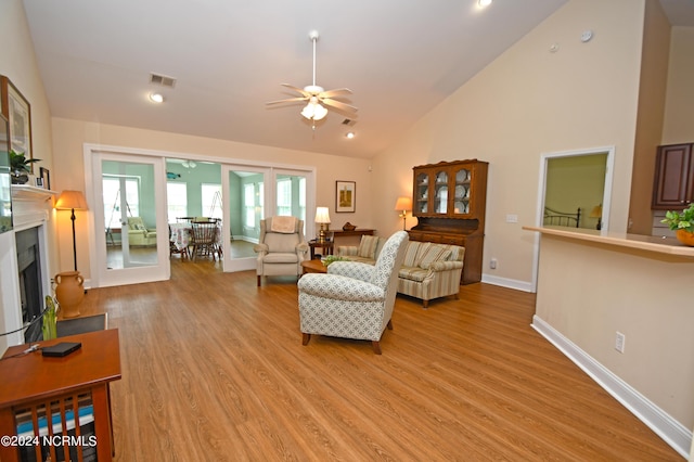 living room featuring ceiling fan, high vaulted ceiling, and light wood-type flooring