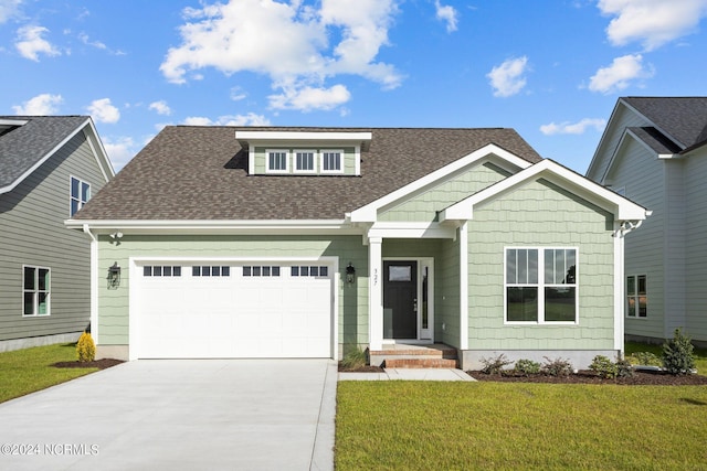 view of front of house with a garage and a front lawn