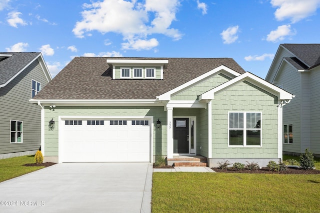 view of front of property with a garage and a front lawn