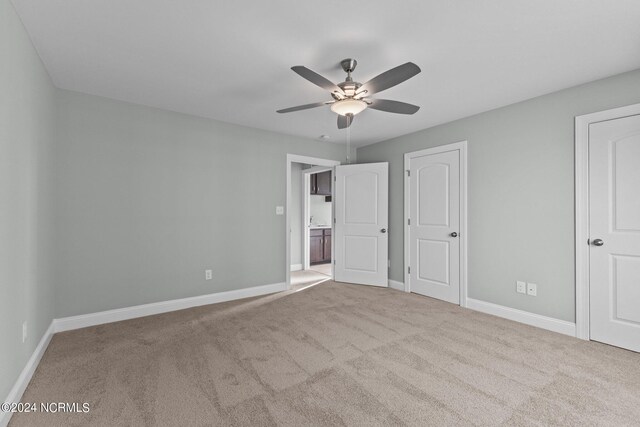 unfurnished bedroom featuring ceiling fan and light carpet