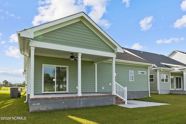 back of property with ceiling fan, central air condition unit, and a yard