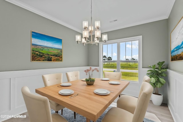 dining area featuring ornamental molding, a chandelier, and light wood-type flooring