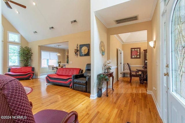 living room featuring wood-type flooring, lofted ceiling, ceiling fan, and ornamental molding