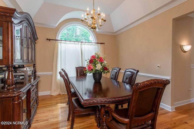 dining space with light wood-type flooring, a tray ceiling, lofted ceiling, and a notable chandelier